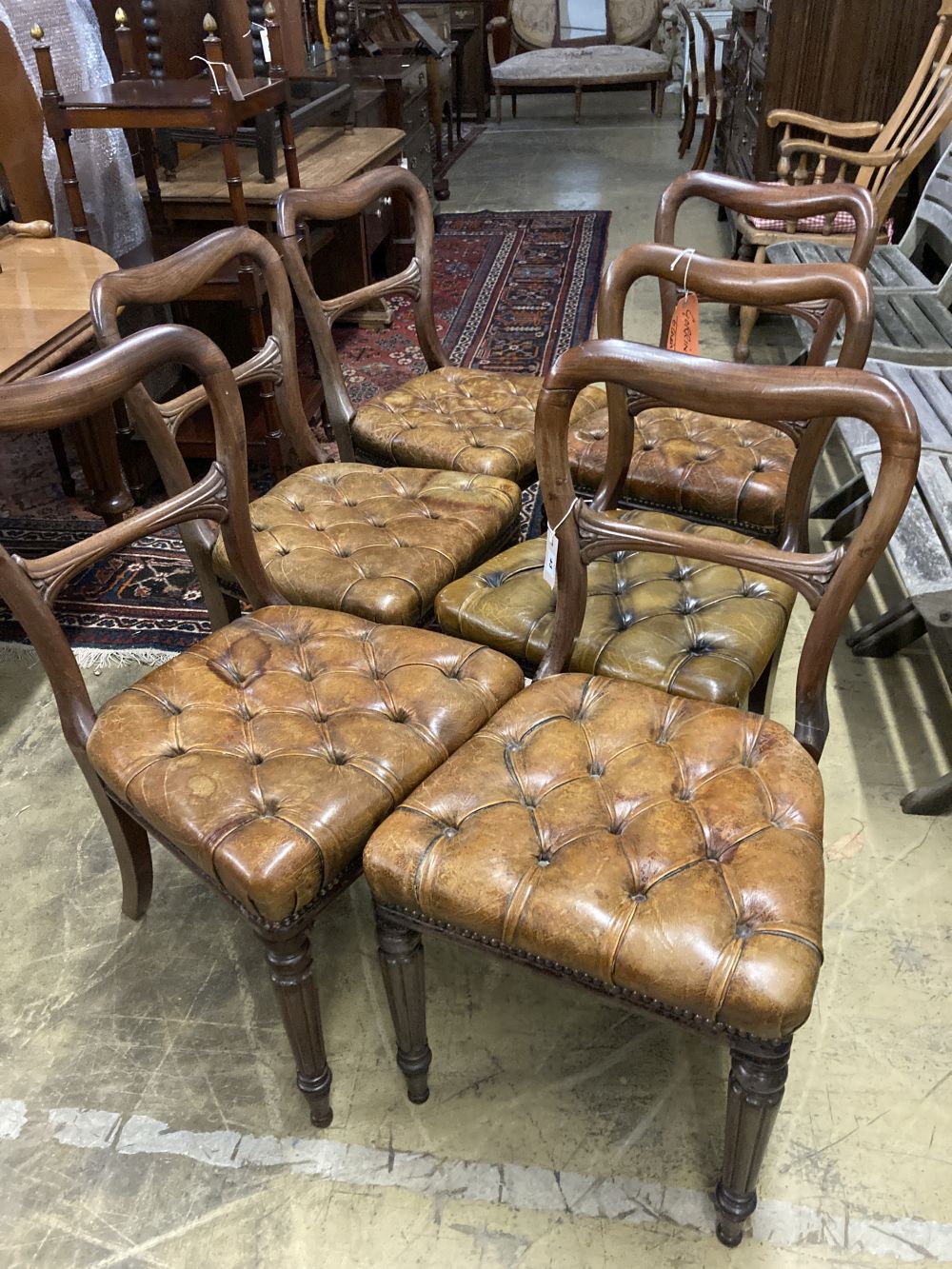 A set of six early Victorian mahogany dining chairs, with buttoned leather seats